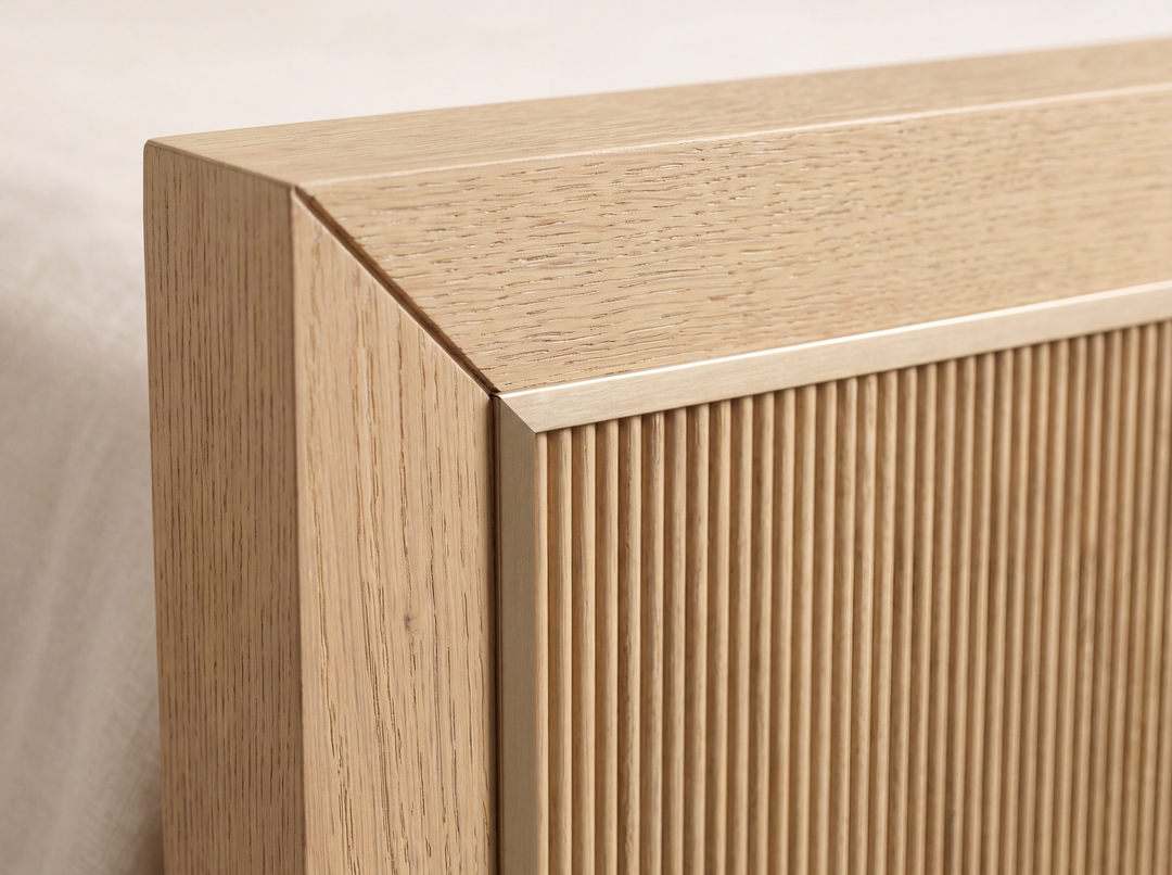Studio detail render of the Sonoma bed: a square mitered White Oak corner and thin muted brass-tone trim around the reeded panel.