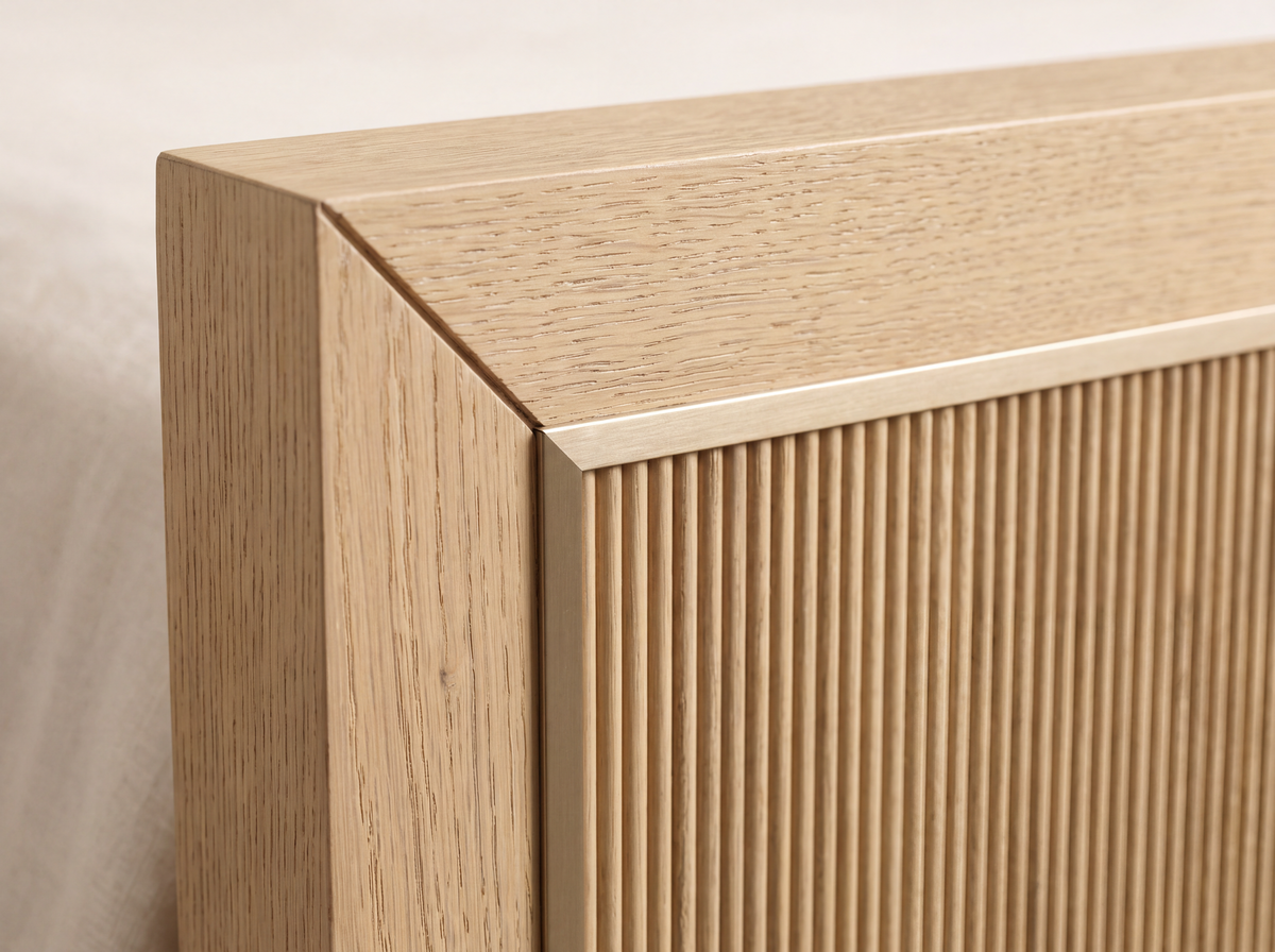 Studio detail render of the Sonoma bed: a square mitered White Oak corner and thin muted brass-tone trim around the reeded panel.